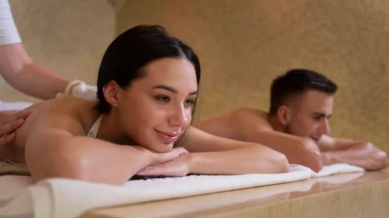 Couple receives relaxing massage treatment in serene spa setting.